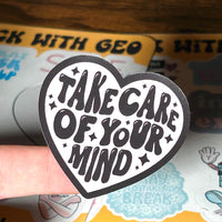 Load image into Gallery viewer, Heart-shaped sticker with 'Take care of your mind' text on a sticker sheet background
